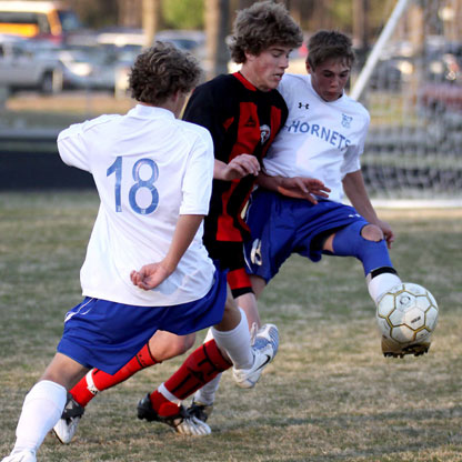 Forrest Fowler, right, and Peter Alverio battle a Russellville player for possession during Tuesday's match at Hornets Stadium. (Photo by Misti Platt)