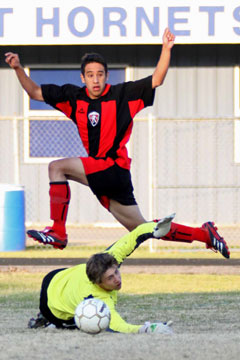 A Russellville play leaps over the diving Devin Norris as the Bryant goal keeper tries to prevent a goal during Tuesday's match. (Photo by Misti Platt)