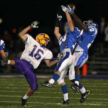 Bryant's Davis Nossaman (23) and Greyson Giles (20) go up for an interception attempt in front of Catholic's Andrew Hugen. (Photo by Rick Nation)