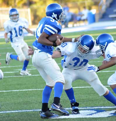 Bryant White defenders Austin Trusty (30) and Steven Murdock (9) draw a bead on Bryant Blue running back Brushawn Hunter (34) as Drew Tipton (16) follows up. (Photo by Kevin Nagle)