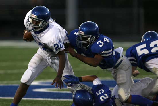 Bryant Blue defenders Brushawn Hunter (34) and Jason Hastings (25) try to bring down Bryant White quarterback K.J. Hill. (Photo by Rick Nation)