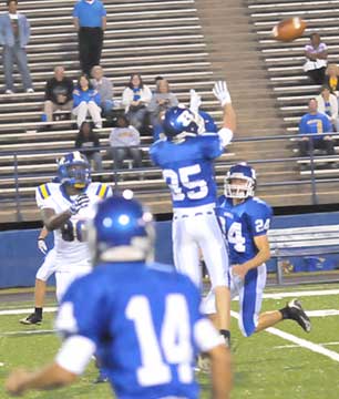 Jesse Johnson (35) leaps to make his interception in front of teammates Hunter Schelle (24) and Caleb Thomas (14). (Photo by Kevin Nagle)