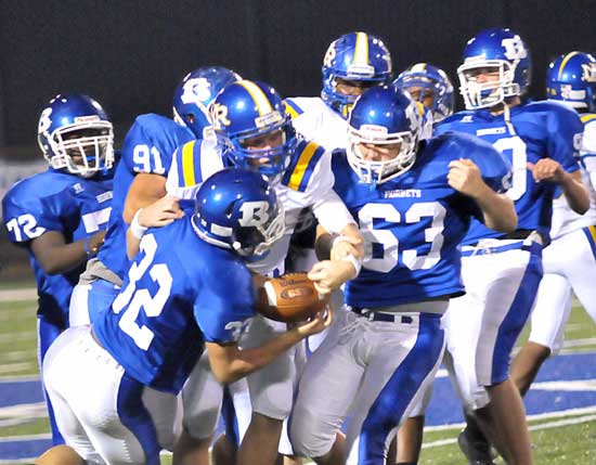 A swarm of Hornets including DeSean Pritchett (72), Tim Kelly (91), Parker Dunn (32), Kaden Mills (63) and Casey Gofourth (90) surround a North Little Rock ball carrier. (Photo by Kevin Nagle)