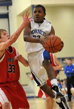 Bryant's C.J. Rainey drives to the hoop past Cabot South's Grant Westlake (33). (Photo by Kevin Nagle)