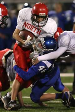 Kyle Lovelace (46) fights off a hold to make a tackle. (Photo by Rick Nation)