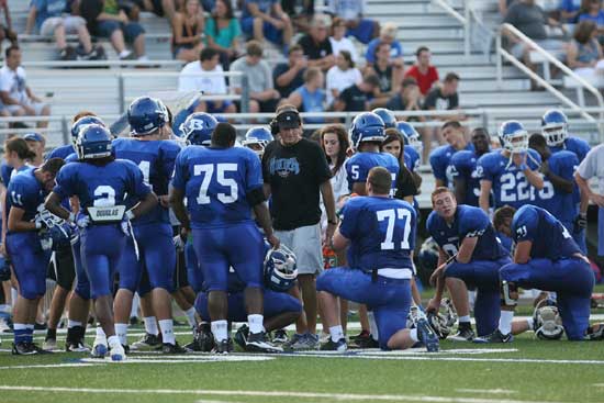 Head coach Paul Calley gathers his offense around him during a break Thursday night. (Photo by Rick Nation)