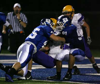Michael Smith (95) and Tim Kelly (91) make a bid to bring down Catholic's Zach Conque for a safety. (Photo by Rick Nation)