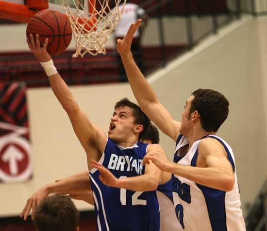 Bryant senior Brantley Cozart (12) flips up a shot after driving past Rogers' 6-6 Josh Anderson. (Photo by Rick Nation)