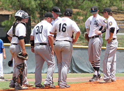 Manager Darren Hurt (30) meets with his infield, starting pitcher Nate Rutherford and catcher Hayden Lessenberry. (Photo by Phil Pickett)