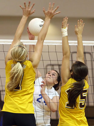 Brooke Howell tries tries to get a hit over against two Lake Hamilton blockers. (Photo by Rick Nation)