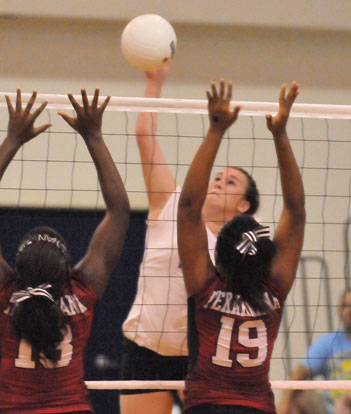 Brooke Howell spikes over a pair of Texarkana Lady Razorbacks. (Photo by Kevin Nagle)