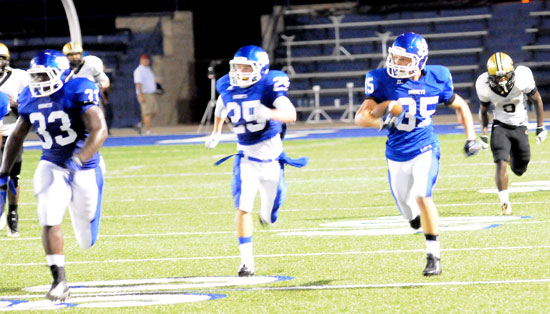 Jake Johnson (35) returns an interception with teammates Tyree Reese (33) and Drew Tipton (25) providing an escort to the end zone. (Photo by Kevin Nagle)