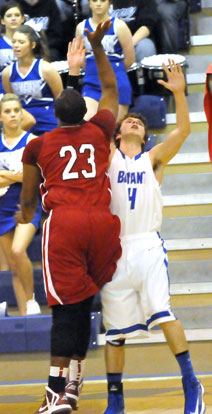 Luke Rayburn (4) takes a charge as Texarkana's Darius Williams goes to the hole. (Photo by Kevin Nagle)