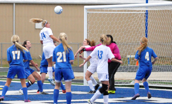 Jacie McMahan heads the ball toward the goal in a crowd. (Photo by Kevin Nagle)