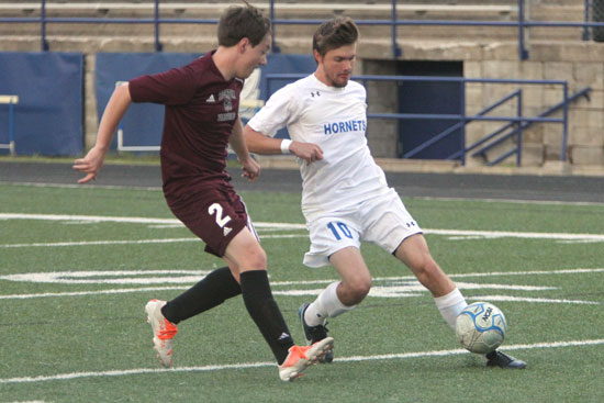 Evan Caddy (10) works around a Benton defender. (Photo by Rick Nation)