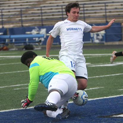 Bryant's Bryce Denker powers a shot past the Benton goal keeper. (photo by Rick Nation)