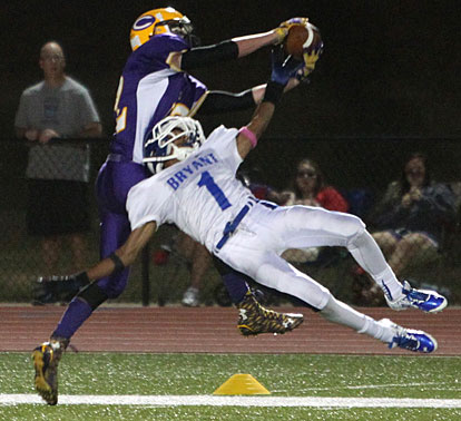 Catholic's Will Plafcan battles Bryant's Andrew Hayes (1) for a pass. (Photo by Rick Nation)