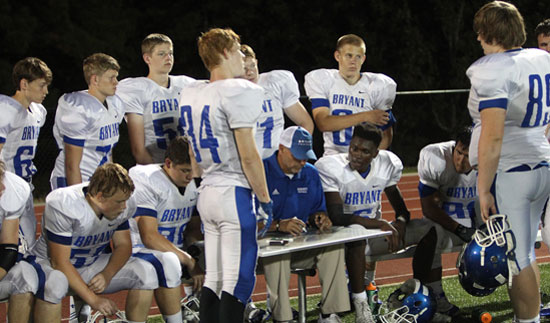 Bryant's offensive linemen gather around o-line coach Kirk Bock on the sideline. (Photo by Rick Nation)