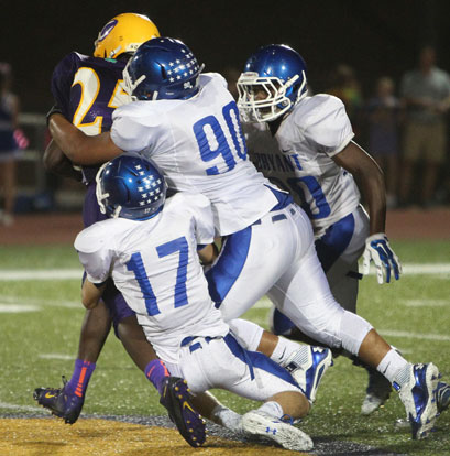 Tyler O'Neal (17), Josh Salguerio (90) and K.J. Terry (20) pile up Catholic running back Sammie Johnson. (Photo by Rick Nation)