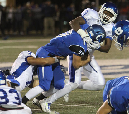 Marvin Moody (18) and Jaelyn Jones (7) make a tackle on a play in which Moody was flagged for a phantom face mask penalty. (Photo by Rick Nation)