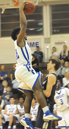 Greenwood's Dustin Lunsford takes a charge as Bryant's Lowell Washington eyes a potential dunk. (Photo by Kevin Nagle)