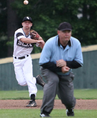 Shortstop Jake East throws to first past the field umpire. (Photo by Rick Nation)